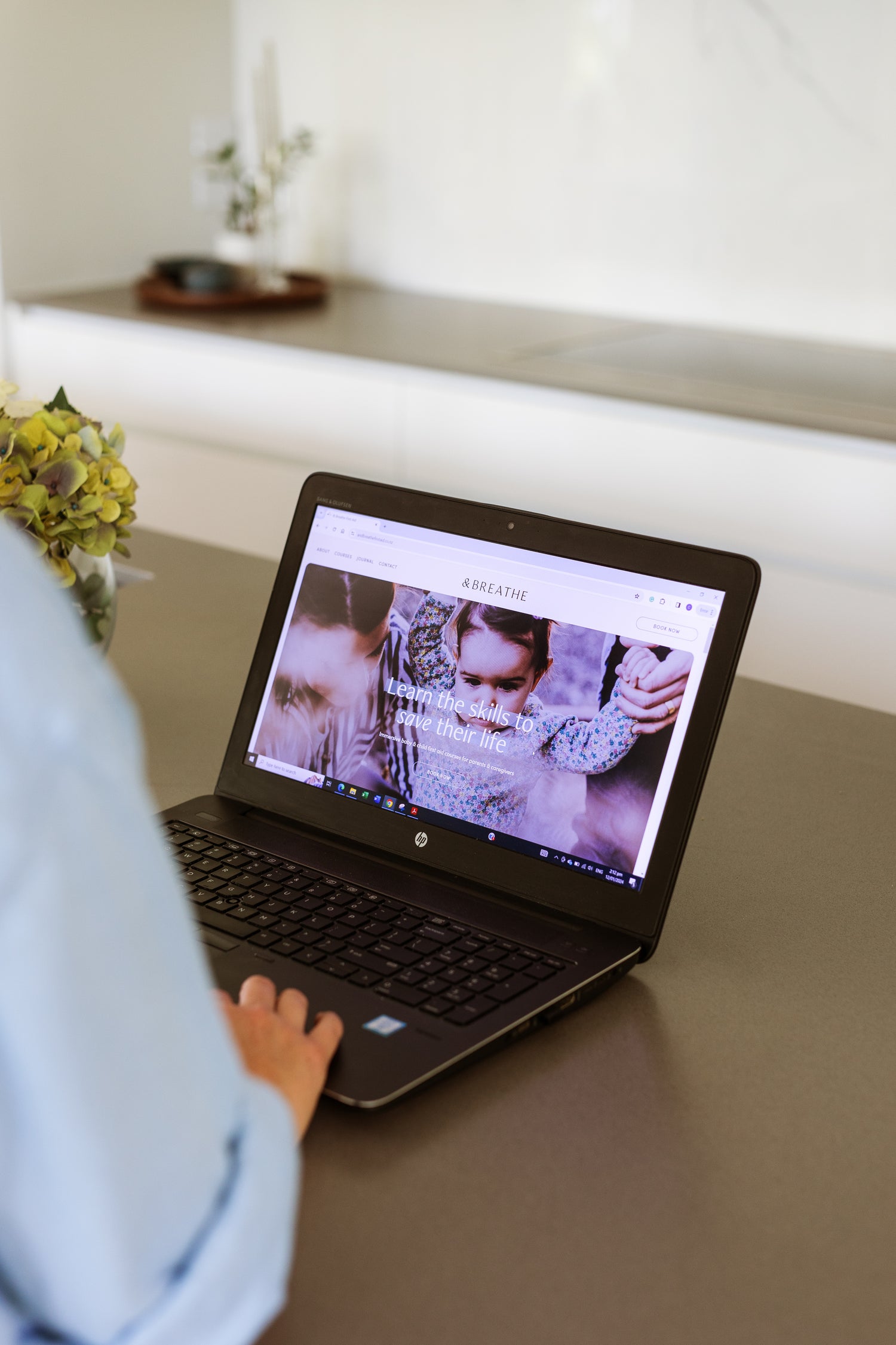 Person using a laptop to access our online child and baby first aid course
